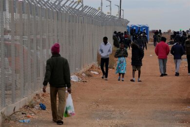 Flüchtlinge laufen an einem Zaun des Aufnahmezentrums Kokkinotrimithia auf Zypern entlang. Immer mehr Migranten landen auf der Mittelmeerinsel an.