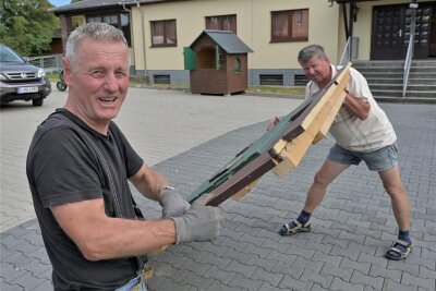 Hans Kunz und Jürgen Seidel beim Aufbau einer Hütte vorm Vereinhaus Thierfeld, wo am Sonnabend gefeiert wird.