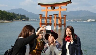 Wir waren hier: Erinnerungsfoto vor Japans berühmtestem Schrein-Tor auf der heiligen Insel Miyajima.