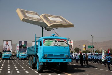 Studenten nehmen an einer Parade zur Unterstützung der Huthi-Bewegung im Jemen teil. Ein Lastwagen trägt ein überdimensionales Modell des Koran.
