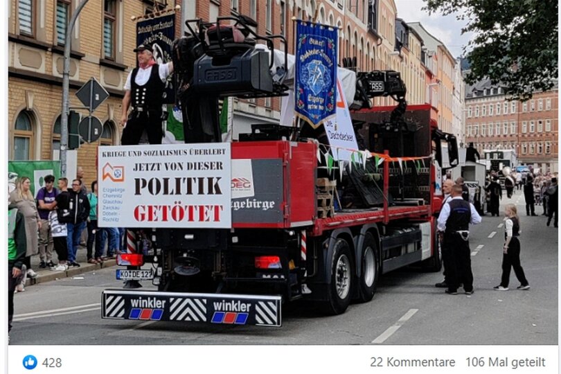 Dieser Screenshot zeigt den Truck der Dachdecker im Festumzug zum Tag der Sachsen in Aue. Auf dem Schild am Heck sind die Worte „Kriege und Sozialismus überlebt“ und „Jetzt von dieser Politik getötet“ zu lesen.