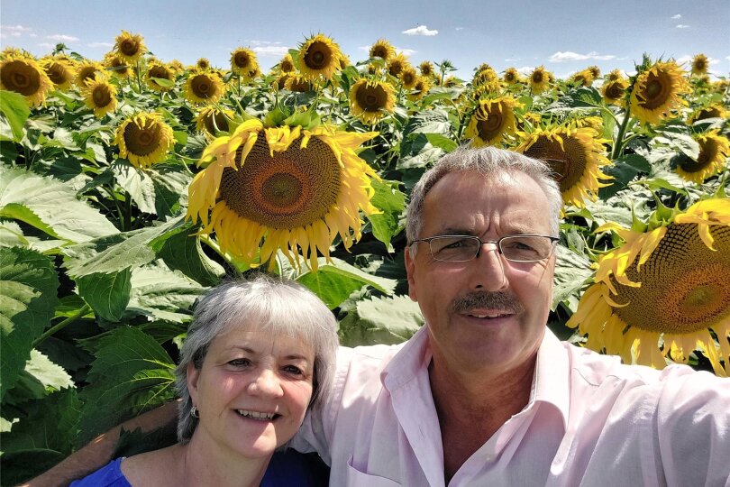 Gabi und Achim Döbrich mitten im Sonnenblumenfeld. Diese Pflanze ist das Wahrzeichen und das Symbol für viele Agrarprodukte in der Ukraine. Das Paar aus dem Vogtland betreibt selbst Landwirtschaft in der Zentralukraine. Trotz des Krieges bleiben sie im Land.