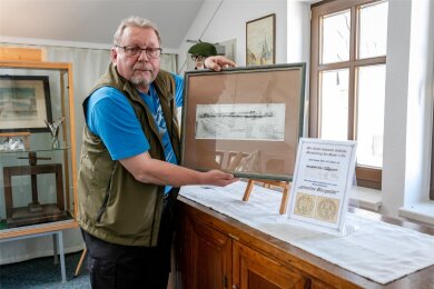 Uwe Kühnert zeigt eine 300 Jahre alte Lithografie, die die älteste bekannte Stadtansicht von Burgstädt darstellt.