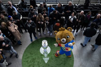Umringt von Fotografen präsentiert Maskottchen Albärt den EM-Pokal im Berliner Olympiastadion.