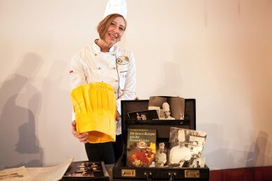 Claudia Lappöhn, Vorsitzende des Vereins Chemnitzer Köche, mit der Kochmütze von Kurt Drummer. Dass die extra für die TV-Aufzeichnungen angefertigte Mütze gelb ist, hatte seinen Grund: Da die Sendungen in Schwarz-Weiß ausgestrahlt wurden, hätte eine weiße Mütze alles überblendet.