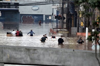 Nach schweren Regenfällen stehen in Porto Alegre, im Süden Brasiliens, die Straßen unter Wasser. Anwohnerinnen und Anwohner versuchen, ihre Habseligkeiten zu retten.