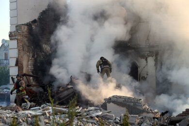 Ein Feuerwehrmann geht durch den Qualm eines brennenden Hauses in Charkiw.