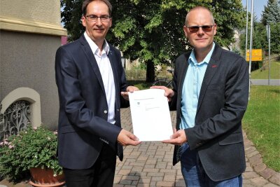 Bürgermeister Axel Röthling (rechts) und Hendrik König, Gebietsleiter Glasfaser bei der Telekom, haben eine Vereinbarung über den Glasfaserausbau in Eppendorf unterzeichnet.