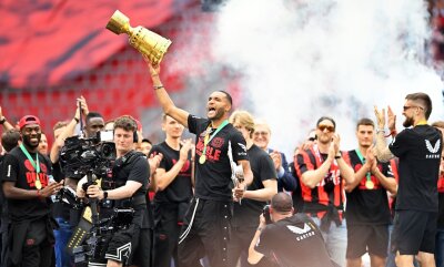 40.000 Leverkusen-Fans feiern Mannschaft in der BayArena - Leverkusens Jonathan Tah (M) präsentiert bei der Meisterfeier in der BayArena die Meisterschale und den Pokal.