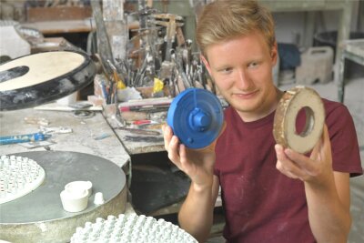 Die Freiberger Porzellan GmbH versucht, Formen für den Porzellanguss am 3D-Drucker herzustellen. Franco Mitzlaff zeigt eine Testvorrichtung aus blauem Kunststoff und einen traditionellen Rahmen.