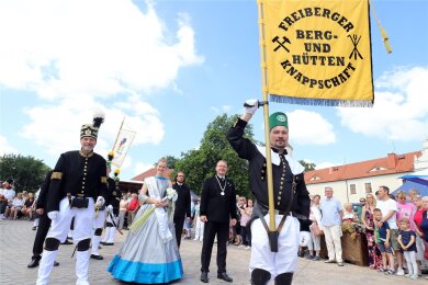 Oberberghauptmann, Silberstadtkönigin und Oberbürgermeister (v. l.) marschieren bei der Bergparade zum Bergstadtfest in Freiberg voran.