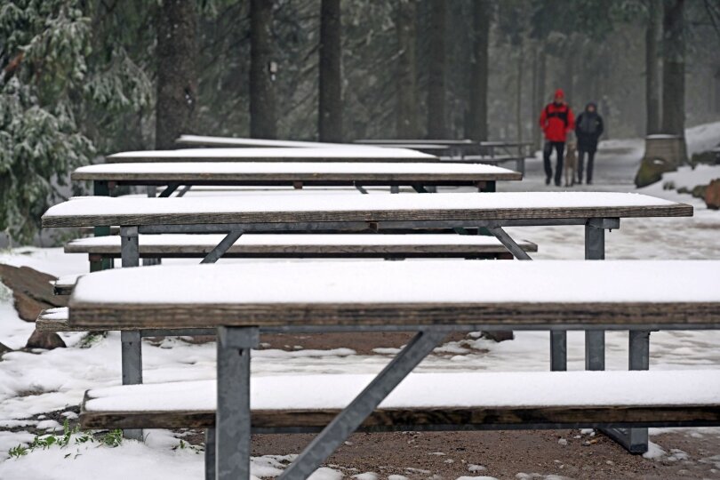 Welch ein Aprilwetter: Der Neuschnee im Schwarzwald hält diese Besucher am Mummelsee nicht davon ab, spazieren zu gehen.