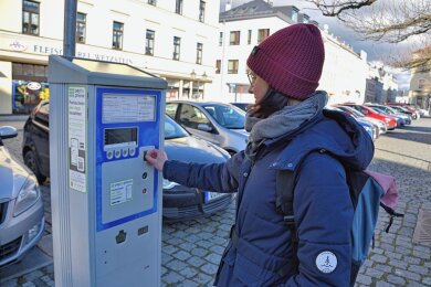 Steffi Gottschald an einem der Parkautomaten am Markt in Oelsnitz. In der Stadt wird die Anschaffung weiterer diskutiert. 