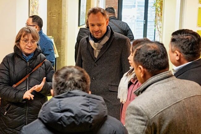 Foto oben: Moritz Hofmann und Julietta Fano sowie Tobias und Linda Mesa (von links) sprachen über Hochzeitsfotos. Foto unten links: Christian Frank, Sven und Daniela Lieberwirth, Steffen Lukas und Claudia Switala (von links) bei der Autoübergabe. Foto unten rechts: Karin Meisel und Alexander Dierks mit Gästen aus der Mongolei.