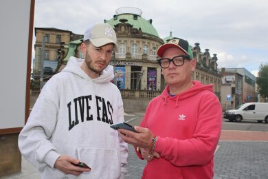 Patrice Fritzsche (links) und Andi Saller vor der Zwickauer Villa Mocc. Auf ihren Handys lasen sie unter Ankündigungen der „Ukraine Night“ in sozialen Netzwerken fassungslos zahllose Hass-Kommentare.