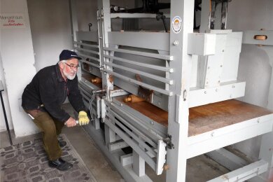 Hier bedient Thomas Börner die rund 100 Jahre alte Wäschemangel per Hand. Dafür gibt es auch einen Motor, doch der wurde bereits für den Transport abmontiert.