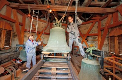 482-jährige Glocke verlässt Kirche - Christian (links) und Daniel Beck hieven die älteste der drei Glocken auf den Schienenschlitten. 