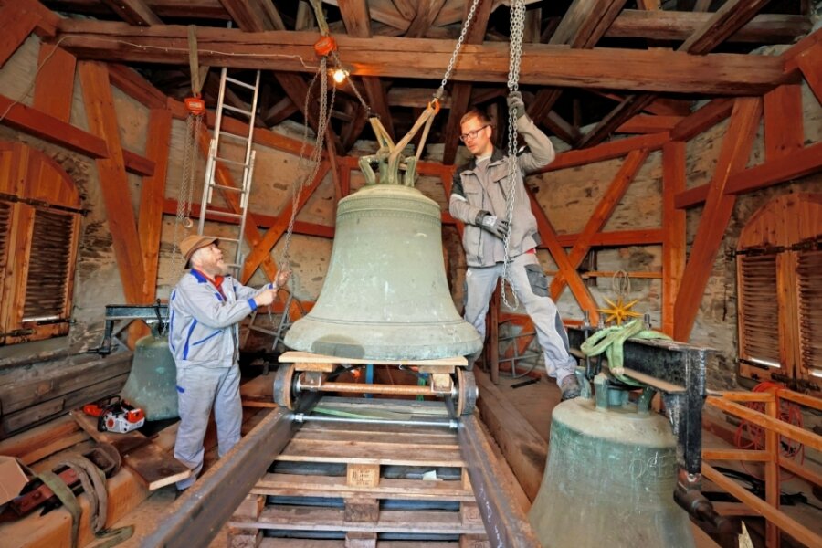 482-jährige Glocke verlässt Kirche - Christian (links) und Daniel Beck hieven die älteste der drei Glocken auf den Schienenschlitten. 