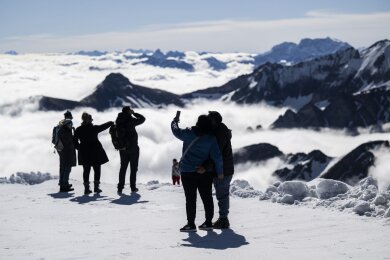 Über den Wolken.. Touristen genießen das Wetter auf dem Berg Chäserrugg in der Schweiz. Auf dem Gipfel kann wegen großer Schneemengen über das verlängerte Wochenende Wintersport betrieben werden.