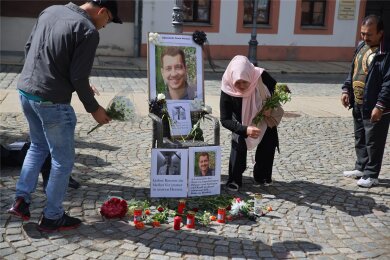 Bei der Kundgebung für Demokratie auf dem Kornmarkt legten Menschen als Zeichen von Mitgefühl und Trauer Blumen vor ein Foto des getöteten Polizisten Rouven Laur.