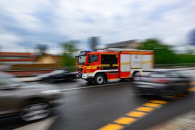 Eine Feuerwehrfahrzeug fährt im Stadtteil Loschwitz mit Blaulicht zu einem Einsatz. (Aufnahme mit langer Belichtungszeit)