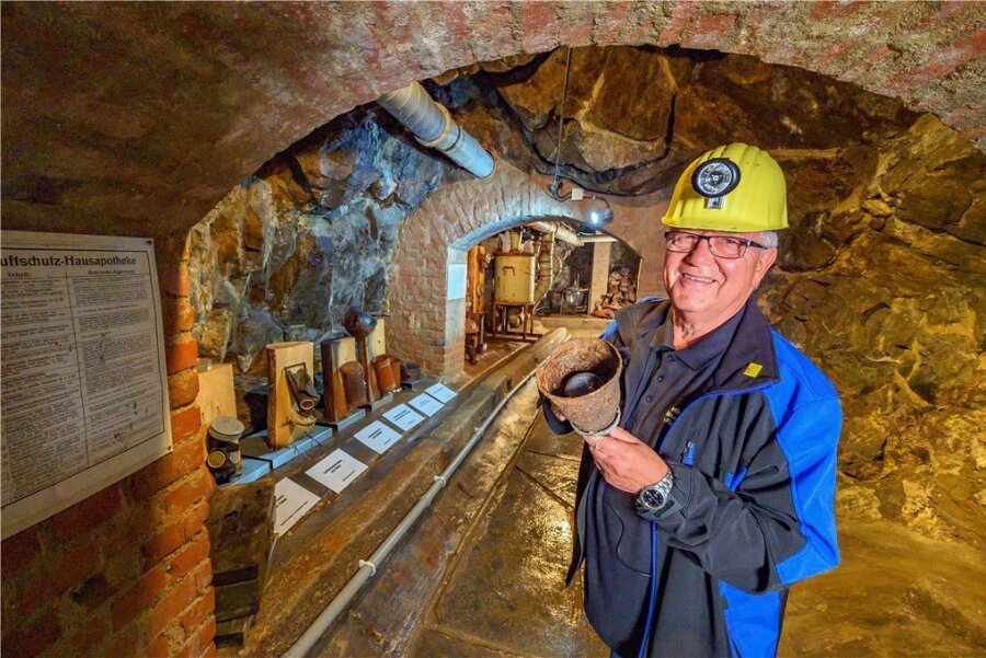 Bergknappenchef Gert Müller zeigt eine Verdunklungslampe aus dem Luftschutzkeller. Die Elektroleitung war auch für den Betrieb der Giftgasfilteranlage wichtig, die noch im Museum zu sehen ist. Bei Stromausfall lief der Betrieb per Handkurbel.