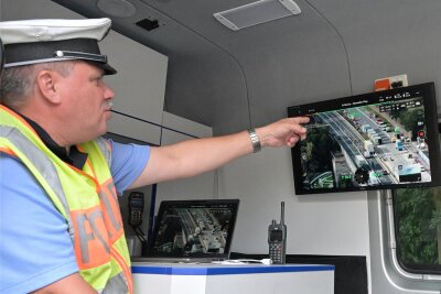 Polizeikontrolle auf der A72 – im Bild Polizeihauptmeister Ralf Ueckert von der LKW-Kontrollgruppe. Er zeigt auf das Livebild der Drohne. Es ist Grundlage für die Kontrollen.