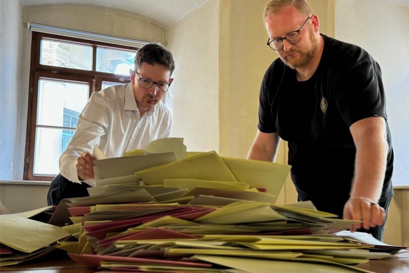 Christian Uhlig (l.) von der Stadtverwaltung und das Team vom Wahllokal in der Annaberger Stadtbibliothek haben mit der Stimmauszählung begonnen.