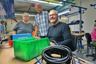 OB Jens Scharff, Werkstattleiter Andreas Müller und Beschäftigte Gabi Brunngreber in der Elektromontage.