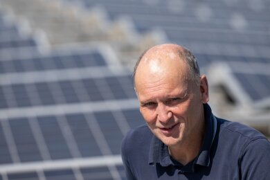 Matthias Gehling, Vorstandsmitglied der Energiegenossenschaft Leipzig, an der Photovoltaikanlage auf dem Dach des Hupfeld Centers.