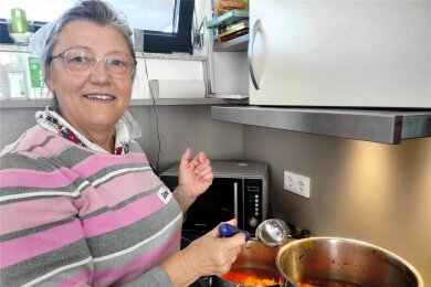 In der DRK-Begegnungsstätte schwingt Elena den Kochlöffel und sagt, was zu tun ist. Dabei lernen alle ein paar Wörter in der jeweiligen Landessprache. Hier wird die Suppe vom großen Topf in servierfreundliches Kochgeschirr umgefüllt.