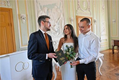 Nach seiner ersten Trauung übergibt Bürgermeister Robert Volkmann (links) dem Hochzeitspaar Hans und Miriam Uhlig die Eheurkunde.