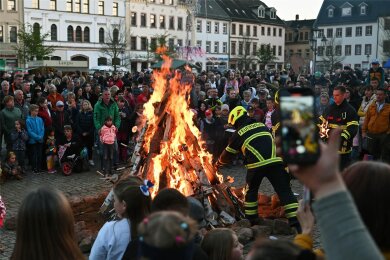 Geschätzt mehr als tausend Besucher lockt das Hexenfeuer – hier ein Foto aus dem vorigen Jahr – in die Innenstadt von Rochlitz. Wenn die Feuerwehrleute nach dem Fackelumzug das Holz entzünden, versammeln sich die Gäste um die wärmenden Flammen.
