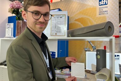 STFI-Wissenschaftler Tobias Richter zeigt gedruckte Heizelemente, die an mehreren Stellen im Elektro-Auto untergebracht werden können.