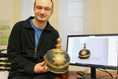 Historische Gegenstände wie diese Pickelhaube, die Museumsleiter Michael Heuck zeigt, gibt es zu sehen.