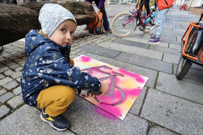 Mit Sprühkreide hat der vierjährige Ingo am Samstag ein Fahrradsymbol auf die Zwickauer Hauptstraße gesprüht. Das soll Aufmerksamkeit für Menschen auf dem Rad schaffen.