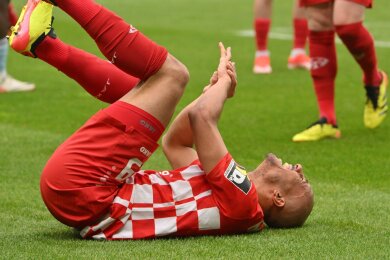 Der Mainzer Karim Onisiwo liegt mit einer verletzten Hand am Boden.