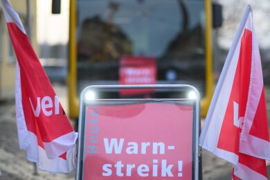 Ein Schild „Warnstreik“ steht vor einem Bus der Dresdner Verkehrsbetriebe (DVB) während des Warnstreiks im öffentlichen Nahverkehr im Betriebshof Trachenberge.