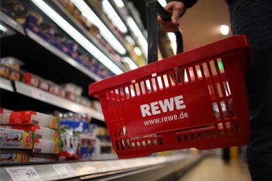 Ein Kunde geht in einem Rewe-Supermarkt mit einem Einkaufskorb am Kühlregal entlang. Eröffnet der Handelskonzern bald auch in Aue eine Filiale?