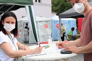 635 Menschen in Oederan geimpft - Die Schönerstädter Landtagsabgeordnete Susan Leithoff (l.) begrüßt Enrico Schulze und nimmt die erforderlichen Daten auf. 