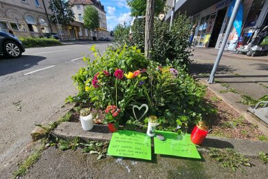 Blumen und Grablichter sind an der Unfallstelle aufgestellt worden.