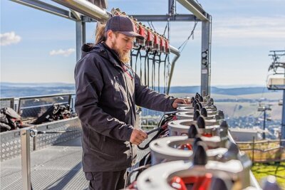 Bei laufendem Betrieb wird hinter den Kulissen schon für die Wintersaison gearbeitet - hierJosef Stürzel bei der Prüfung der Rollen und Karabinerhaken an einem Lift in Oberwiesenthal.