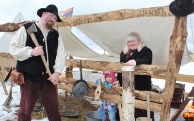 Auf dem Gelände der künftigen Westernstadt "Old Miners Creek" bei Geyer hat am Wochenende trotz Schnee und Kälte ein Siedlercamp als Vorläufer eröffnet. Im Bild: John Big Tackle, Tochter Lena und Ann Davis. Auch Holz hacken hielt warm. 