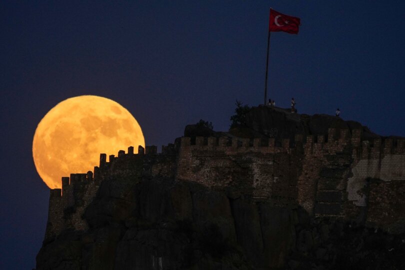 Groß und gelb: Der Vollmond geht hinter der alten Burg Karahisar in Afyonkarahisar in der Zentraltürkei auf.
