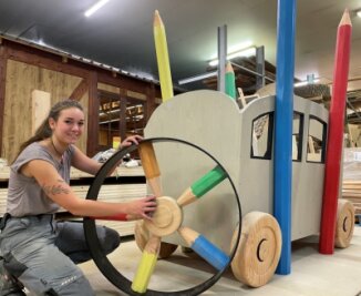 Lisa Lang, Lehrling im zweiten Lehrjahr bei Massivholz Design, ist federführend bei der Umsetzung des Projekts "Bauernhof" für Waschleithe. Im Bild zeigt die junge Frau aus Annaberg den "Traktorreifen." 