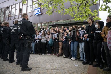Polizei und Protestierende der propalästinensischen Gruppe "Student Coalition Berlin" stehen sich bei einer Demonstation auf dem Theaterhof der Freien Universität Berlin gegenüber.