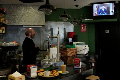 Ein Barkeeper beobachtet, wie der spanische Ministerpräsident Pedro Sánchez eine Fernsehansprache hält.