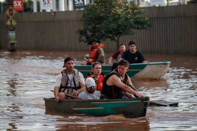 Mitglieder eines Rettungsteams bei der Evakuierung von Menschen, die von einer Überschwemmung betroffen sind.