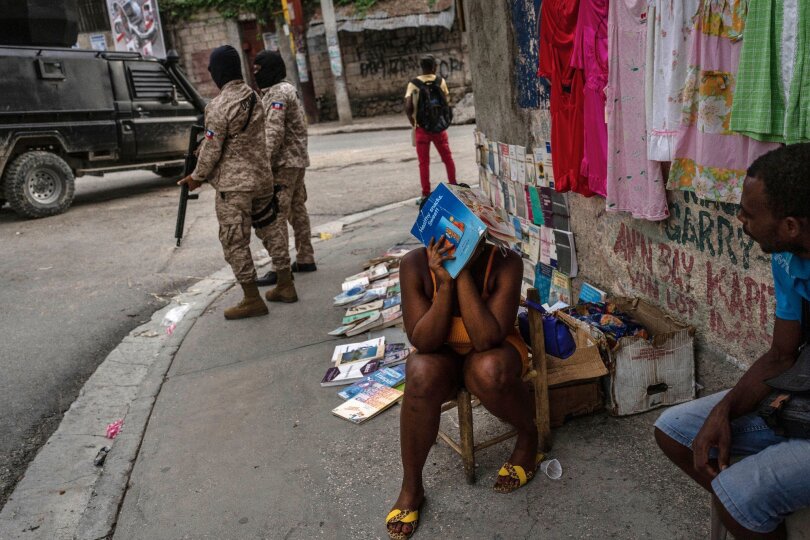 Polizisten patrouillieren neben einer Straßenhändlerin in der Innenstadt von Port-au-Prince. Bewaffnete Gruppen kontrollieren große Teile von Haitis Hauptstadt. Zuletzt eskalierte die Gewalt weiter. Mehr als 1500 Menschen wurden in den ersten drei Monaten des Jahres getötet.