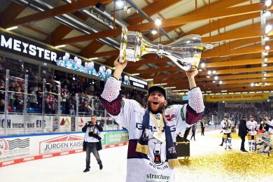 Berlins Yannick Veilleux jubelt nach dem Gewinn der deutschen Eishockey-Meisterschaft mit dem Pokal.